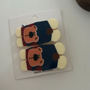Detail of two cute acrylic bear hair clips with floral patterns on a display card