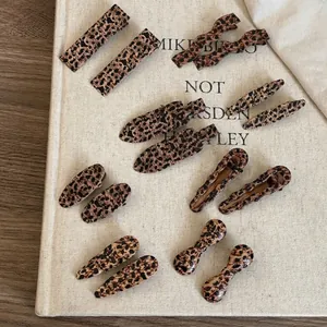 Vintage leopard print hair clip set with multiple shapes on an aesthetic autumn background