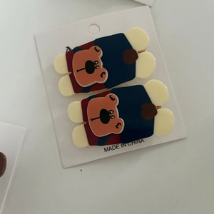 Detailed view of two cute bear acrylic hair clips displayed on a white product card