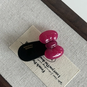 Detailed macro view of a handmade acetate bow hair clip with golden France engraving