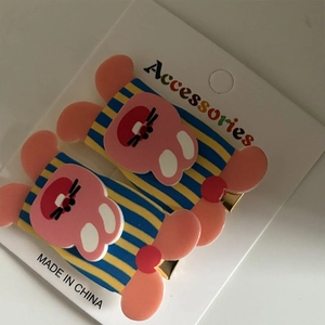 Close-up of pink acrylic bunny hair clips with striped details on a display card