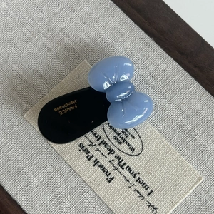 Detail of a handmade blue acetate bow hair clip with gold France engraving