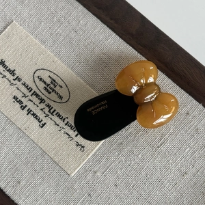 Detail of a vintage amber acetate bow hair clip with France Handmade gold lettering