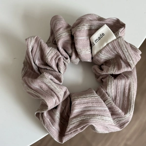 Detail of mauve striped scrunchie with a handmade woven label and pleated texture