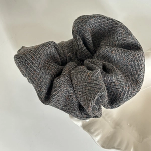 Oatmeal grey herringbone cotton linen scrunchie with red fiber dots on ceramic dish