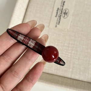 Detail of red plaid fabric hair clip with a large resin ball in French vintage style