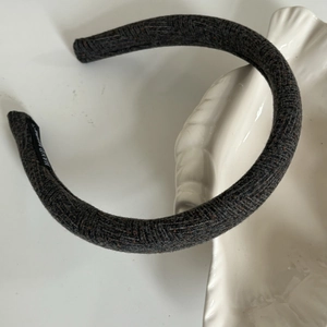 Detail of dark grey tweed headband with hand made label and diagonal woven texture