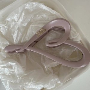 Matte mauve French shark hair clip with gold lettering in white textured packaging