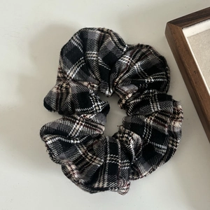 Detailed view of plaid scrunchie with classic grey and white check fabric texture