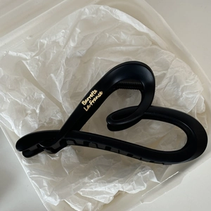 Detail of matte black shark hair claw featuring golden Barrette La France lettering