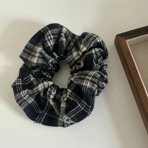 Detailed close-up of a plaid scrunchie with soft flannel texture for winter hairstyles