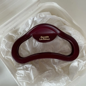 Detail of matte burgundy hair claw clip with golden Barrette La France text engraving