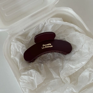 Close-up of a matte burgundy French hair claw clip with golden Barrette La France lettering