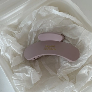 Close-up of a matte mauve claw clip with gold Barrette La France lettering for women