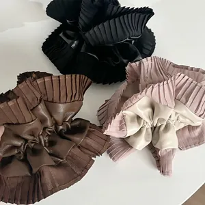 Flat lay of leather and lace scrunchies in black, dark brown, and dusty pink colors