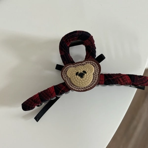 Close-up of British red plaid hair claw clip with a cute beige woven bear detail