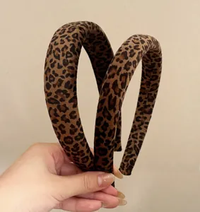 Close-up of leopard print sponge headband with velvet texture shown in hand