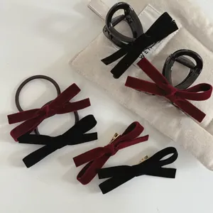Detail of velvet bow hair clips and scrunchies in wine red and black colors