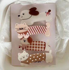 Détail de quatre barrettes à cheveux en acrylique avec chats et chiens sur carte