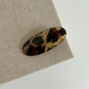 Classic leopard print oval hair clip with a glossy finish and vintage aesthetic
