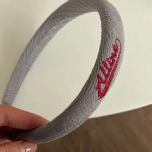 Thick light gray knitted headband with red Allure embroidery for women hair styling