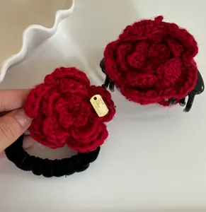 Détail de la pince à cheveux fleur rouge crochetée main et chouchou en velours