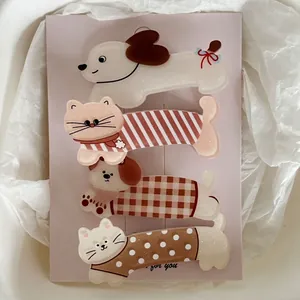 Lot de quatre barrettes en acrylique chat et chien avec motifs marron sur carte de support
