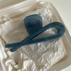 Pinza per capelli blu polvere stile francese a pois rossi su carta stropicciata bianca
