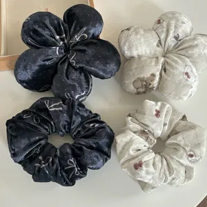 Détail de chouchous en velours avec motifs d'ours et fleurs en 3D dans un ensemble de quatre