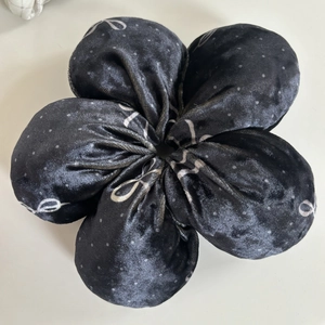 Gros plan d'un chouchou fleur en velours noir avec des pois blancs et motifs décoratifs