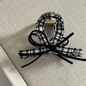 Detail of tweed checkered hair claw with black velvet bow and France handmade gold tag