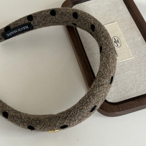 Detailed macro view of handmade polka dot wool headband with padded sponge structure