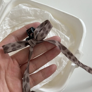 Leopard print bow hair claw clip with silk ribbon texture for elegant women's styling