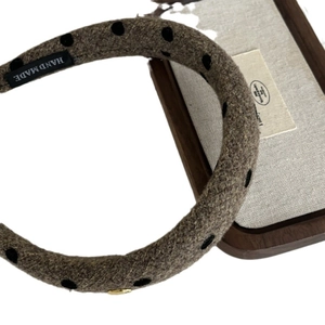 Elegant brown wool headband with black polka dots and a golden metal charm pendant