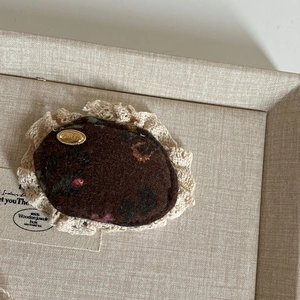 Nahaufnahme der Vintage-Haarklammer mit braunem Blumenmuster und Spitze