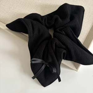 Oversized black ribbed knit scrunchie with satin bow for elegant ponytail styling