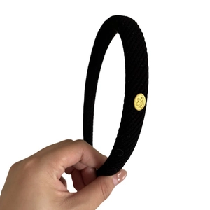 Gray rib knit headband with elegant gold oval logo plaque for women hairstyle