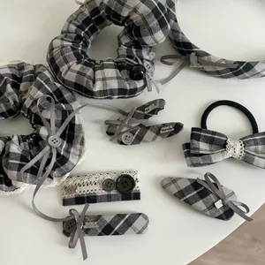 Detailed view of grey plaid hair accessories set with lace trim and buttons