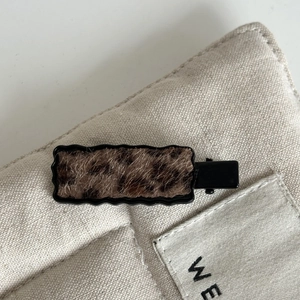 Plush leopard print cherry hair clip attached to a beige canvas bag for cute styling