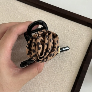 Vintage leopard print rose hair claw clip in black resin held in hand for women