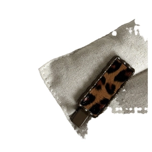 Pince à cheveux rectangulaire à motif léopard avec bords ondulés sur tissu