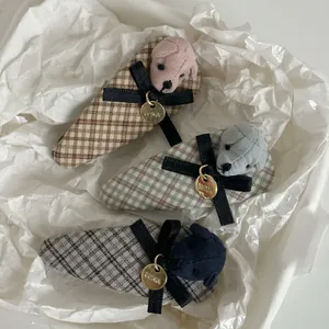 Close-up of three checkered hair clips with black bows and plush bear charms