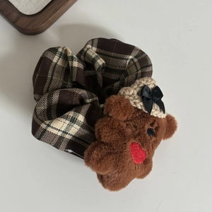 Détail de chouchou à carreaux marron avec mignon ours en peluche 3D et bonnet tricoté