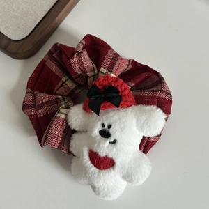 Détail de chouchou à carreaux rouges avec ours en peluche blanc et bonnet rouge
