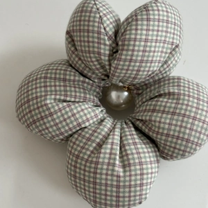 Detail of floral plaid scrunchie with green and purple patterns and central white pearl