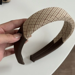 Detail of a brown plaid padded headband with soft sponge filling for women