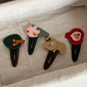 Detail of handmade leather hair clips for girls featuring cute tree and ice cream designs