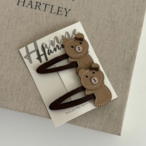 Set of two brown faux leather bear hair clips for girls on a white display card