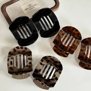 Chic acetate hair claw clips in black and leopard patterns on white background
