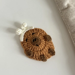 Makroaufnahme von handgefertigtem Capybara-Häkelprojekt mit kleiner Krone und Stickerei
